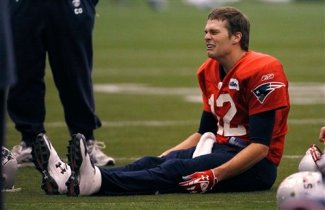 New England Patriots quarterback Tom Brady (12) jokes with teammates during NFL football practice in Foxborough, Mass., Wednesday Dec. 7, 2011. (AP Photo/Charles Krupa)